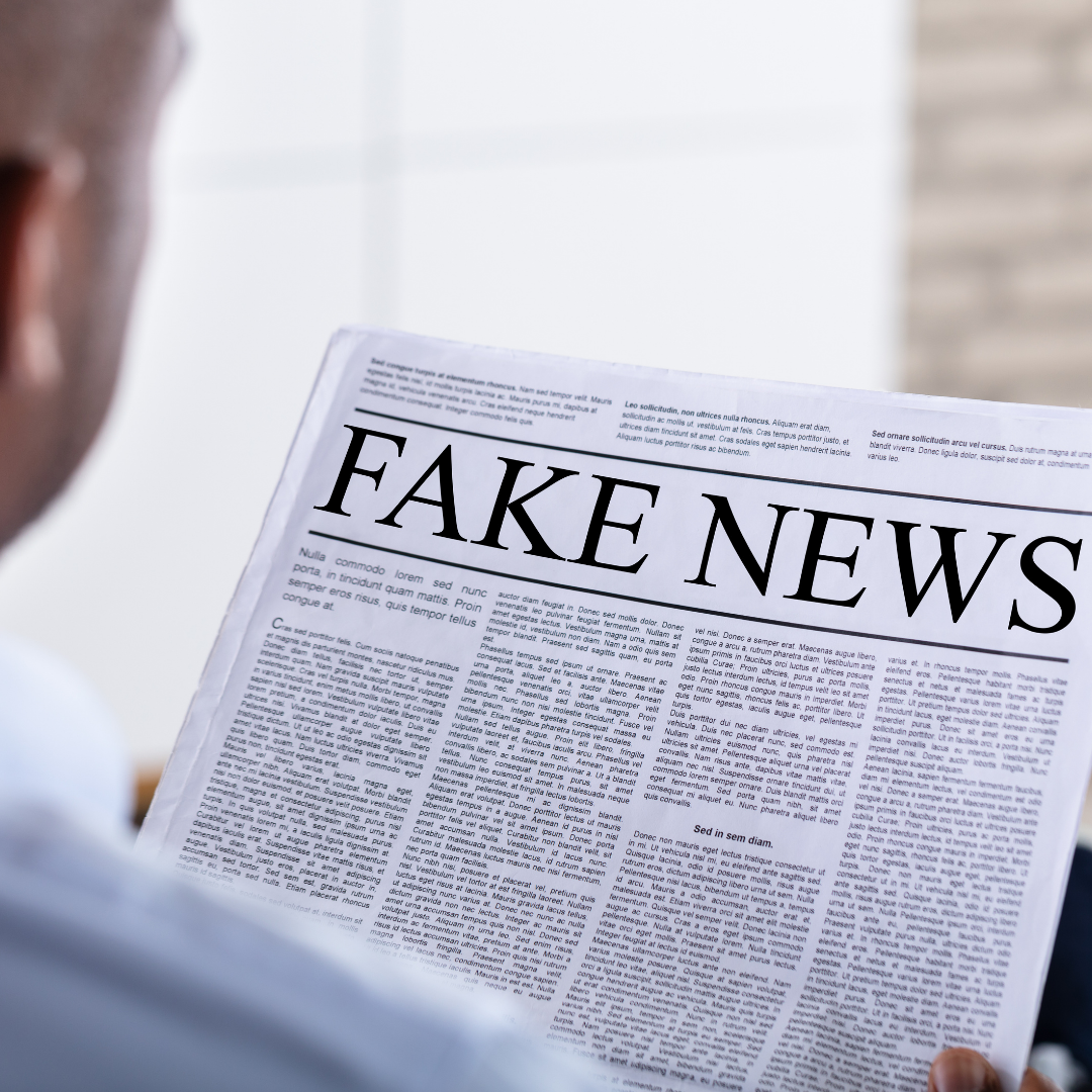 Personne qui lit un journal en Côte d'Ivoire avec comme gros titre, fake news
